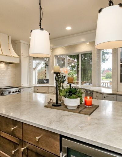 A kitchen with marble counter tops and a center island.