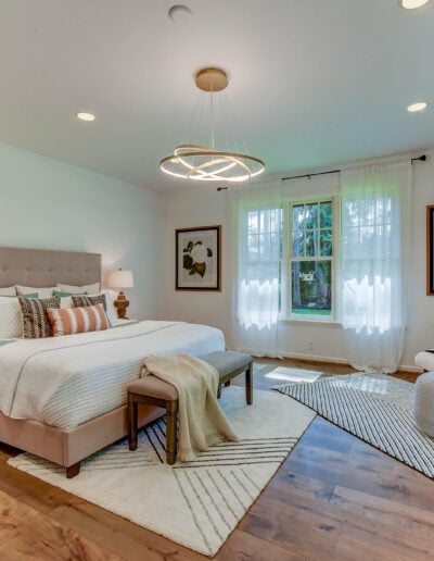A bedroom with hardwood floors and a bed.