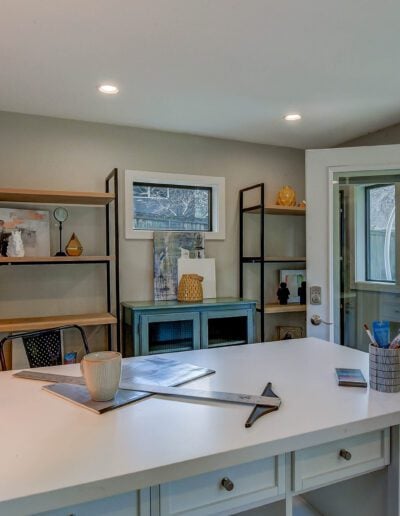 A home office with a white desk and a sliding glass door.