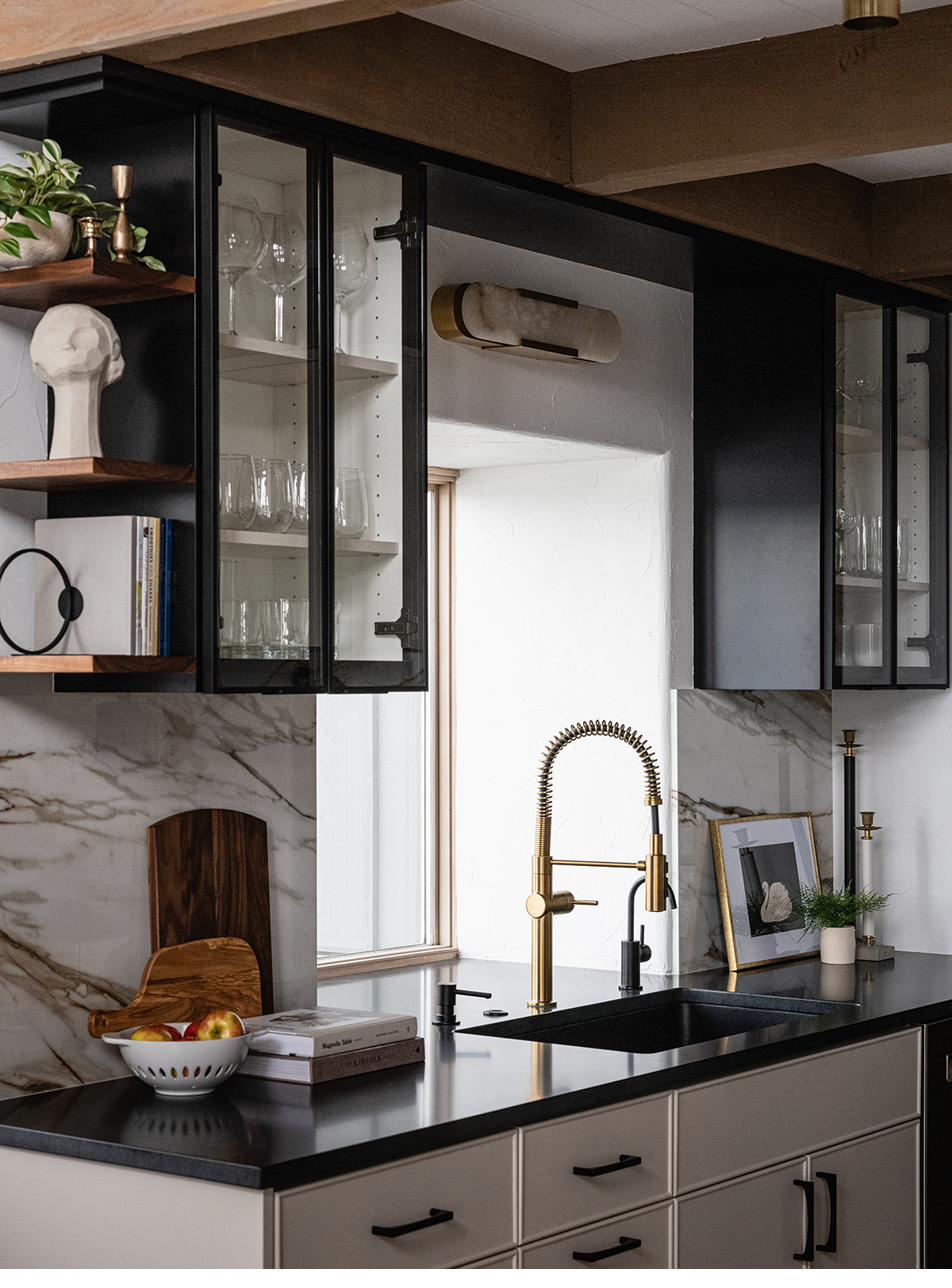Wet bar detail with marble backsplash and glass cabinetry