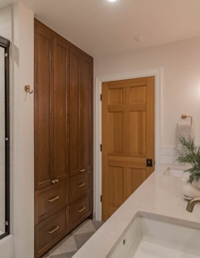 Guest bathroom with a walk-in shower, wood linen tower and quartz vanity in North Bend