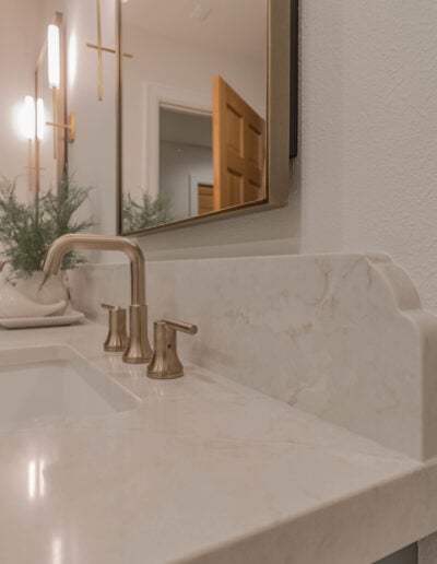 Brushed gold faucet and undermount sink detail on a quartz countertop