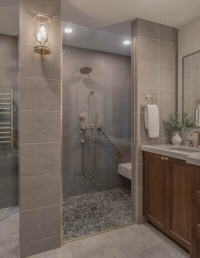 Primary bathroom remodel in North Bend with a walnut vanity, glass-front cabinetry and a curbless tile shower